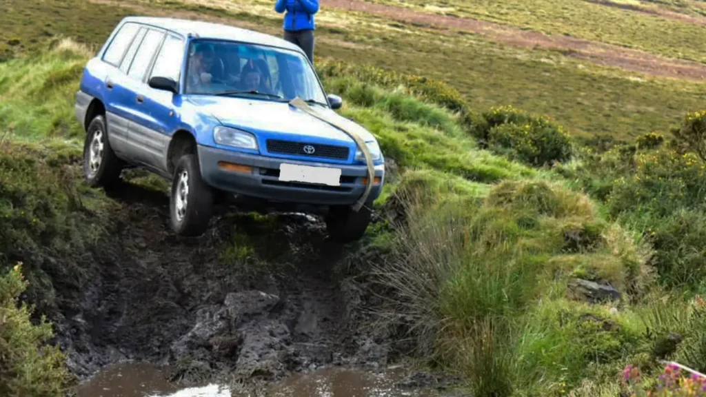 Blue Toyota 4x4 on a muddy road.