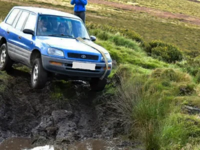 Blue Toyota 4x4 on a muddy road.