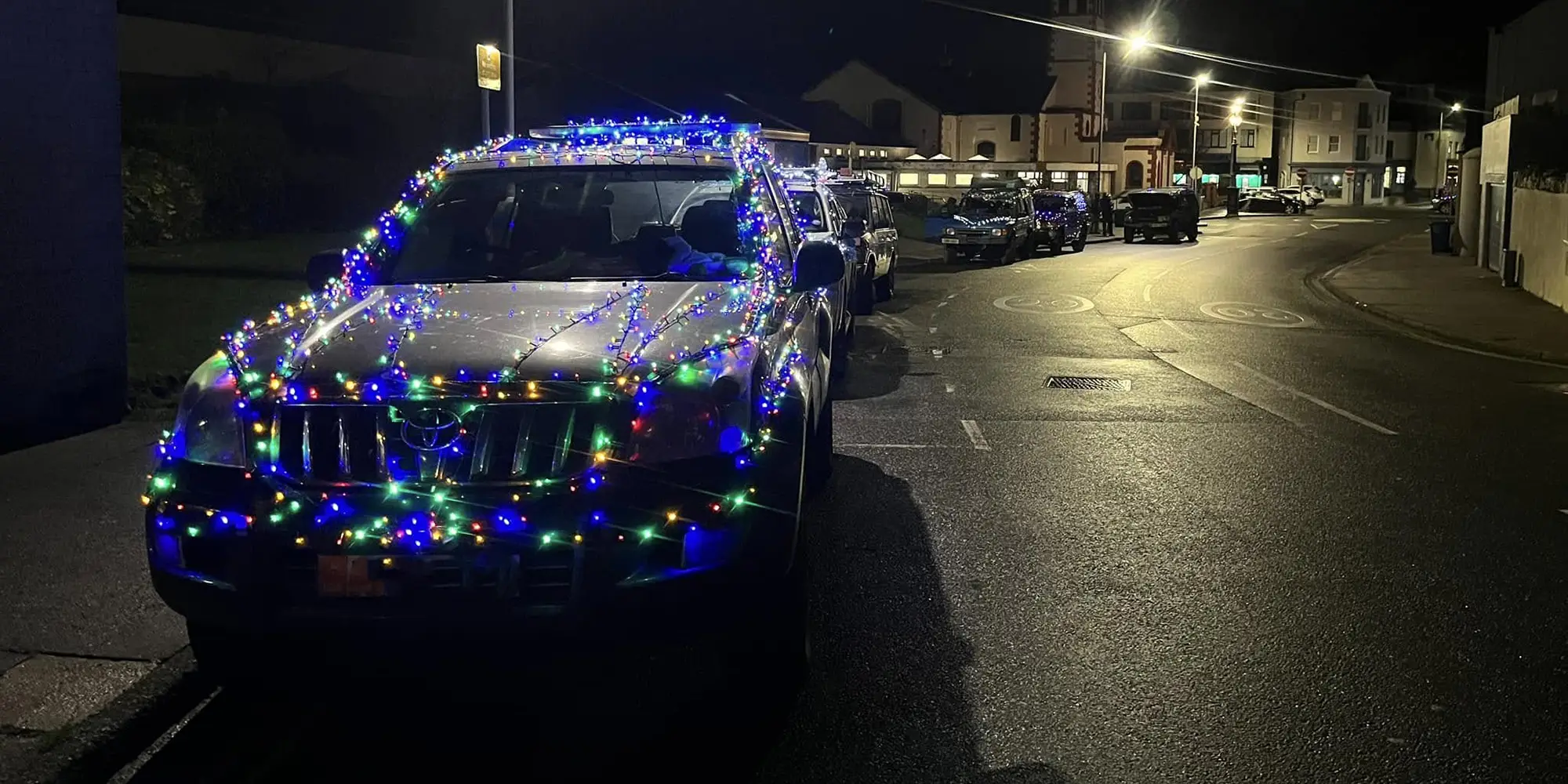 Toyota covered in Christmas lights for a social drive.